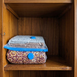 After: the same bedding vacuum-sealed flat on the same shelf, with space left above