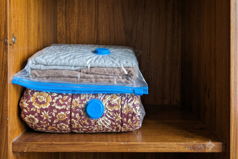 Sealed vacuum bags lying flat on an almari shelf with most of the shelf space freed