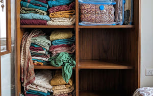 Pakistani wooden almari: clothes crammed loose on the left, the same clothes vacuum-sealed flat on the right